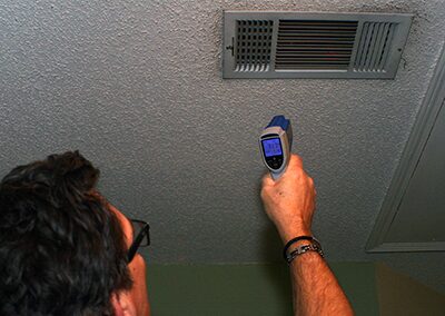 Person using infrared thermometer on vent.