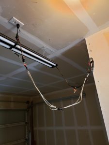 A garage door is being installed with two lights.